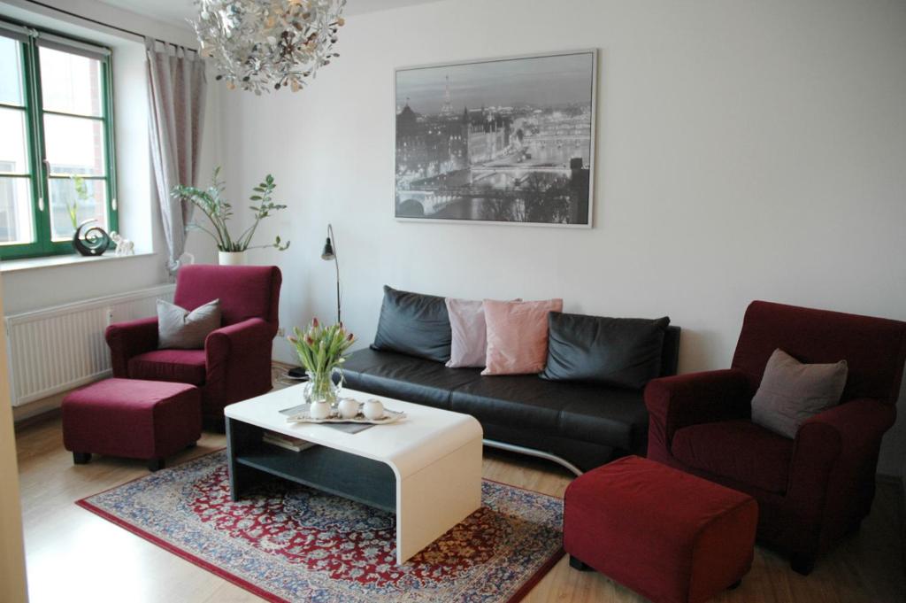 施特拉尔松德桑达帕特公寓的客厅配有沙发、两把椅子和一张桌子