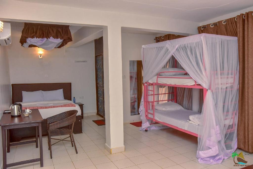 基苏木Beach View Hotel - Kisumu的一间卧室配有一张双层床、一张桌子和一张床