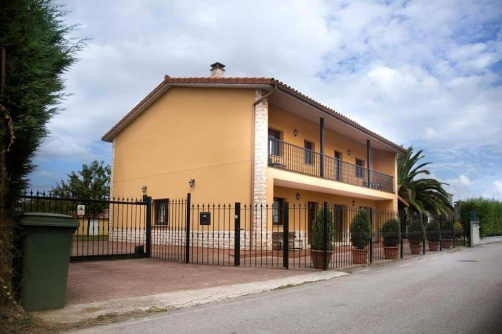 阿维莱斯Villa Paula的一条黄黄色的建筑,在街道旁设有黑色的栅栏