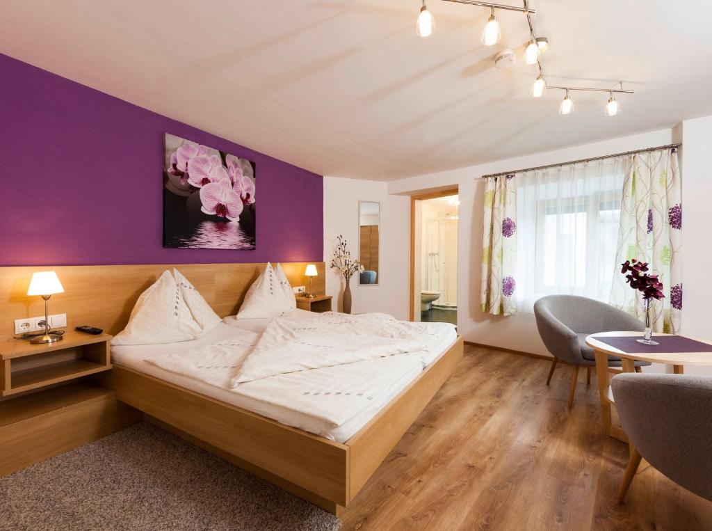 因青洛斯勒霍夫公寓的一间卧室配有一张床和紫色的墙壁