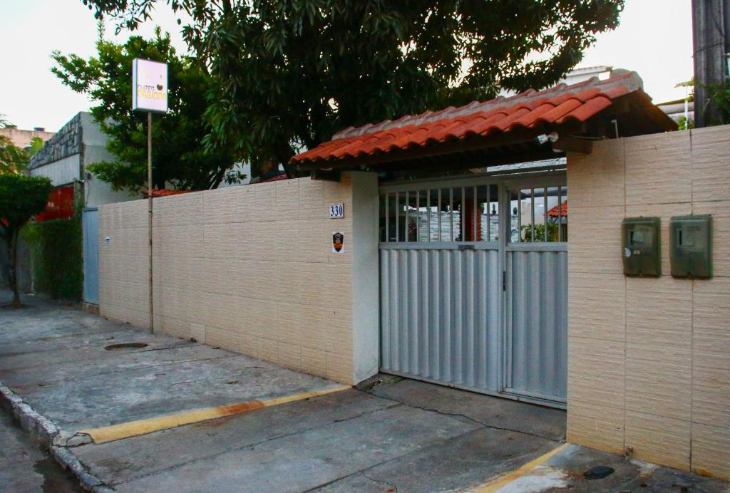 嘎林海斯港Suites Carioca的一座带门和栅栏的建筑