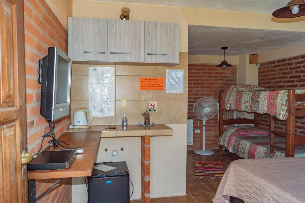 圣罗莎卡拉穆奇塔县Posada Tinktinkie的一间卧室配有一张床和一张书桌及电视