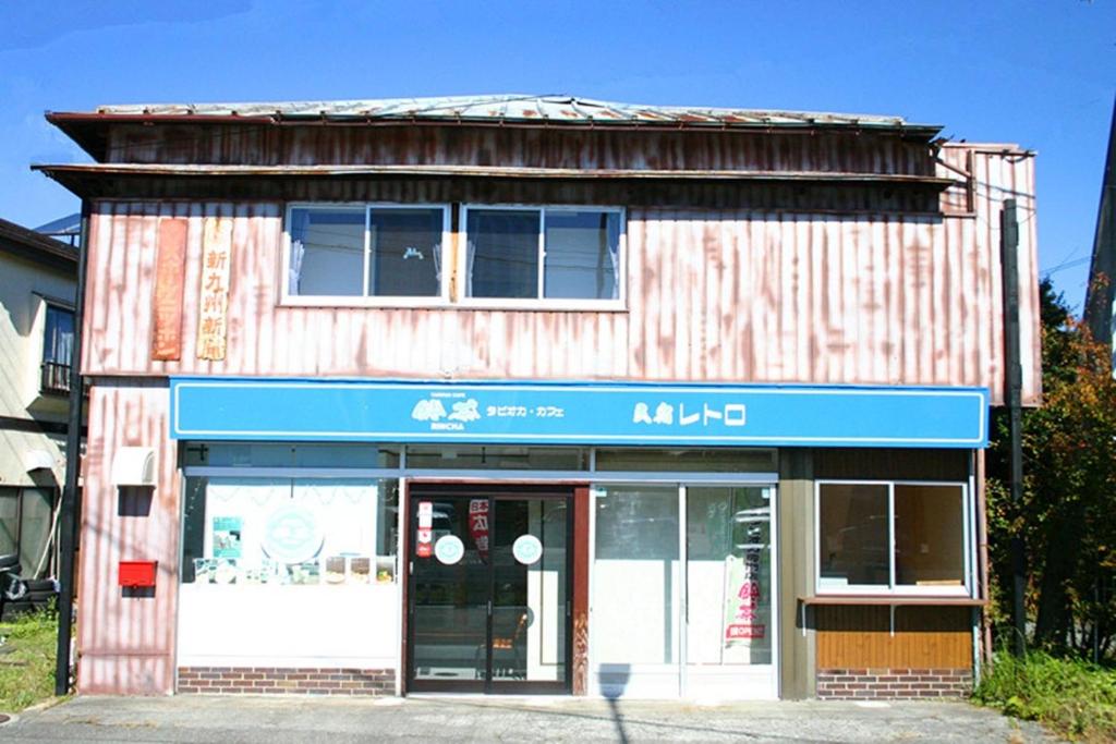 阿扎格瓦RETRO retro - Vacation STAY 03865v的商店前有蓝色标志的建筑物
