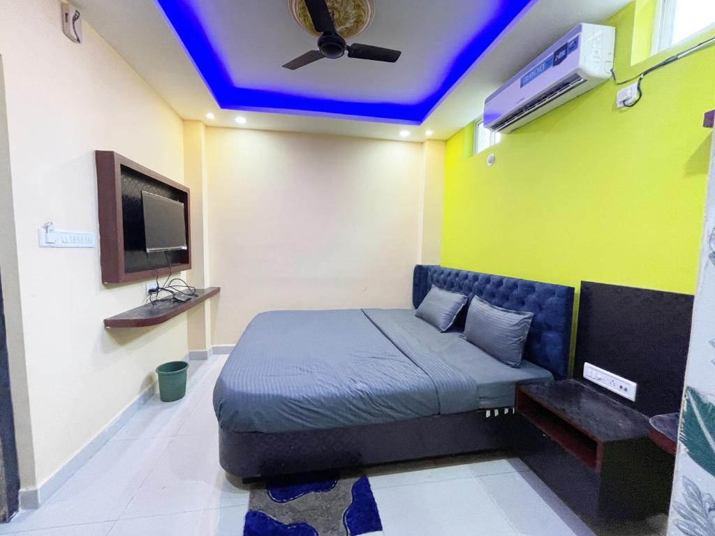 普里ojotrip Hotel Basanti INN- puri的客房设有一张床和带电视的天花板
