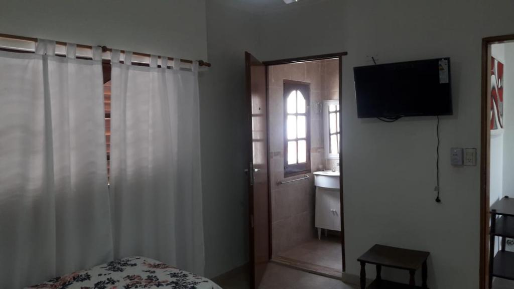 瓜莱瓜伊Alojamiento Guemes的一间卧室设有一张床、一个窗口和一台电视