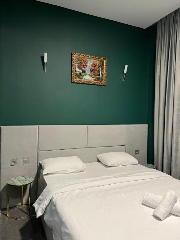阿克托比Hotel NOMAD的一间卧室设有两张床,墙上挂着一幅画