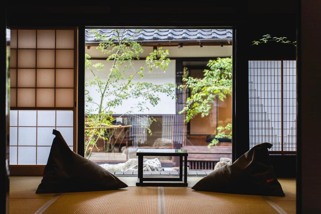 TakahashiCastle Town Contemporary Ryokan 天籟 - TENRAI -的两个枕头坐在门前的桌子上