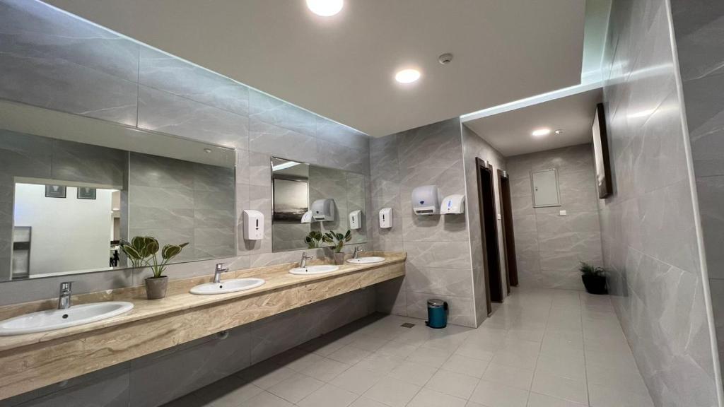 亚喀巴Twins Boutique Hotel的一间带两个盥洗盆和大镜子的浴室
