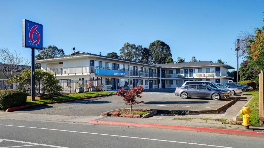 阿克塔Motel 6-Arcata, CA Cal Poly Humboldt的停车场内有车辆的建筑物