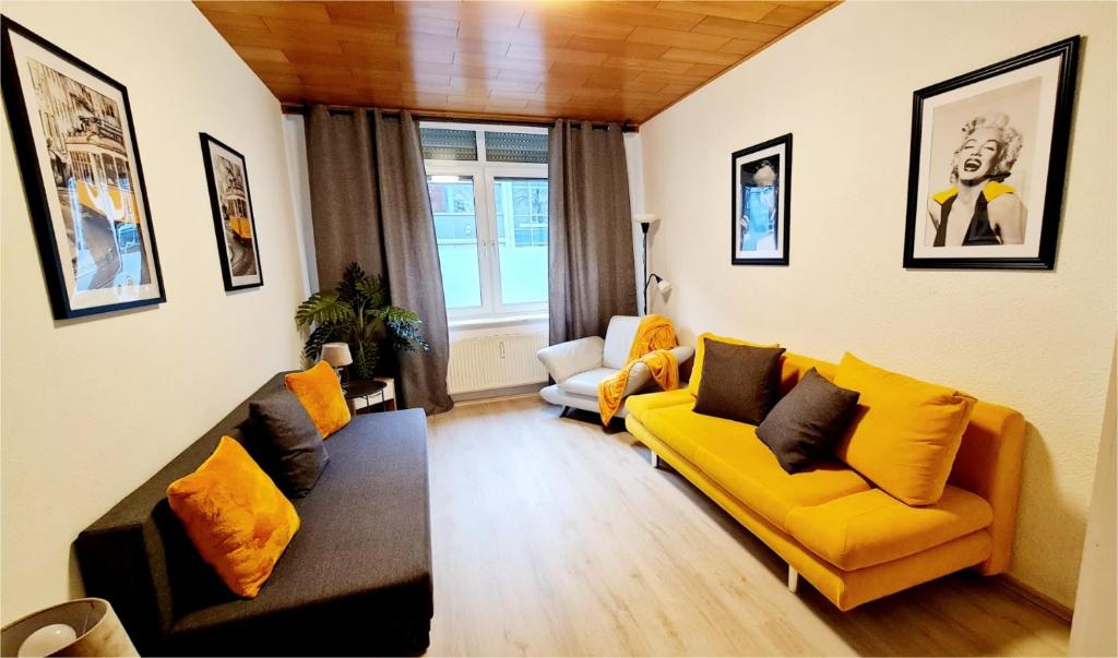 杜伊斯堡ELENA flat Sonnenblumen Duisburg Zentrum的客厅配有黄色的沙发和椅子