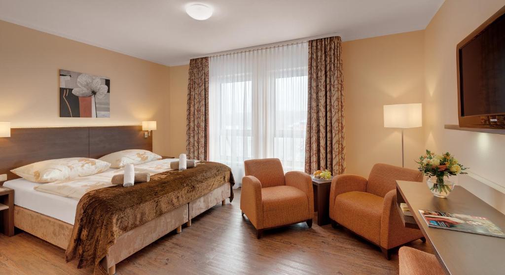 奥伯霍夫奥伯霍夫斯驰洛斯伯格酒店的酒店客房,配有一张床和两把椅子
