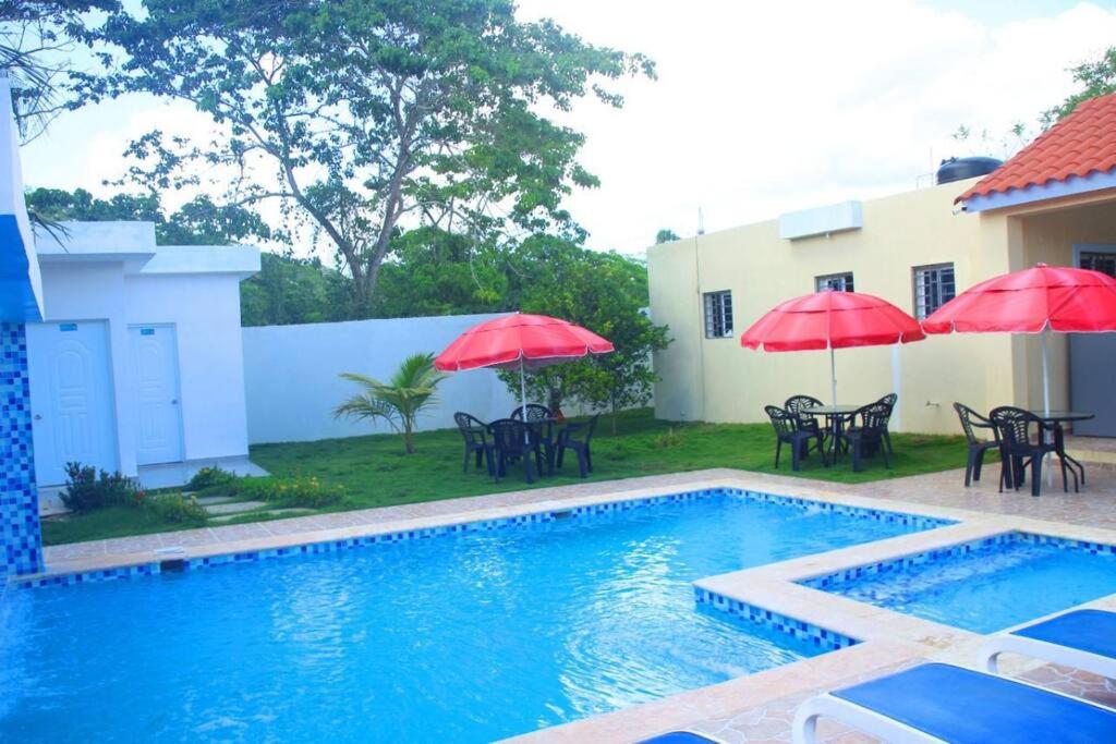 HigueyRancho Oasis, Residencial Sanate的房屋旁的游泳池配有桌子和遮阳伞