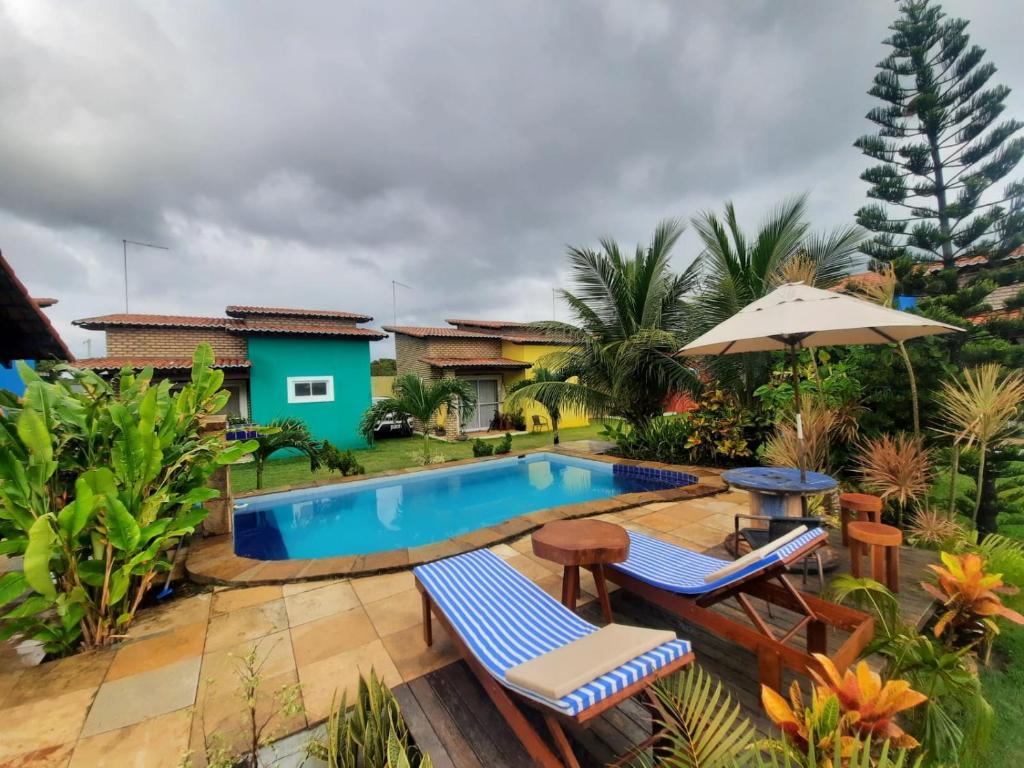 皮帕Villa da Praia的后院设有游泳池、椅子和房屋