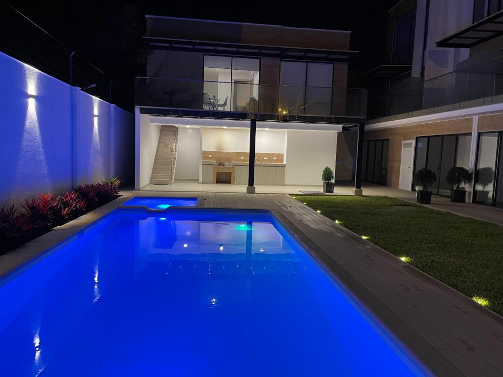 萨利纳斯Suite Nueva Salinas-Chipipe的夜间在房子前面的游泳池