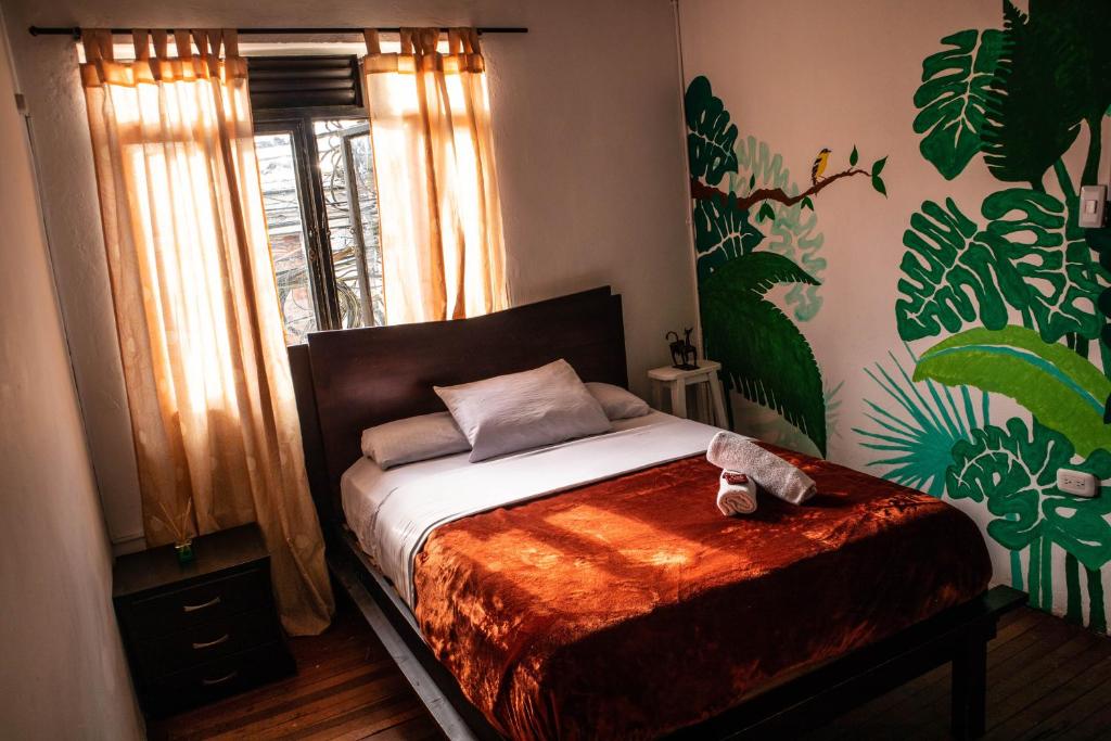 圣罗莎德卡瓦尔Kimaná Hostal的一间卧室配有一张铺有木地板的床。
