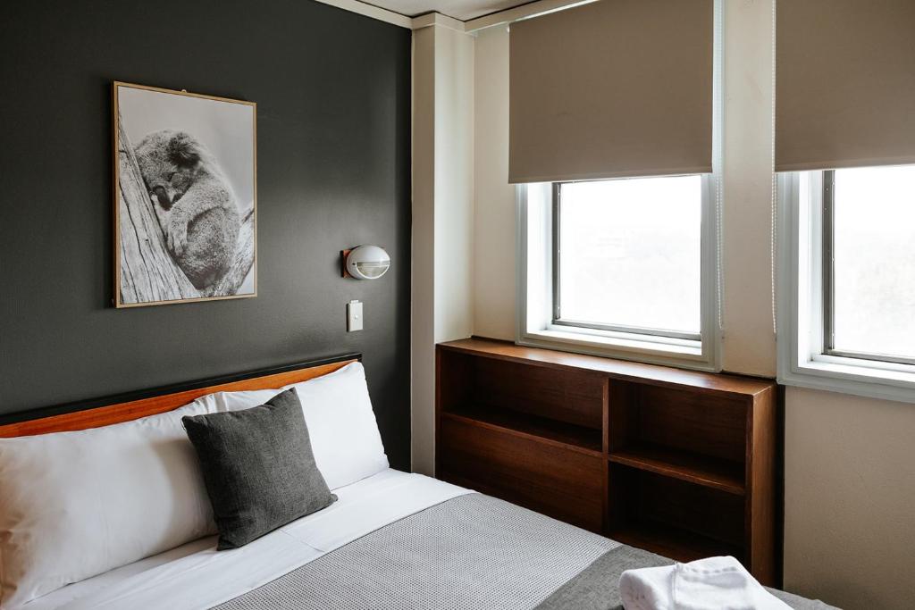堪培拉Canberra Accommodation Centre的一间卧室设有一张床和两个窗户。