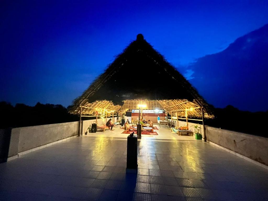 黎明之村WoodPacker Hostel Auroville Pondicherry的金字塔建筑,晚上有带照明的庭院