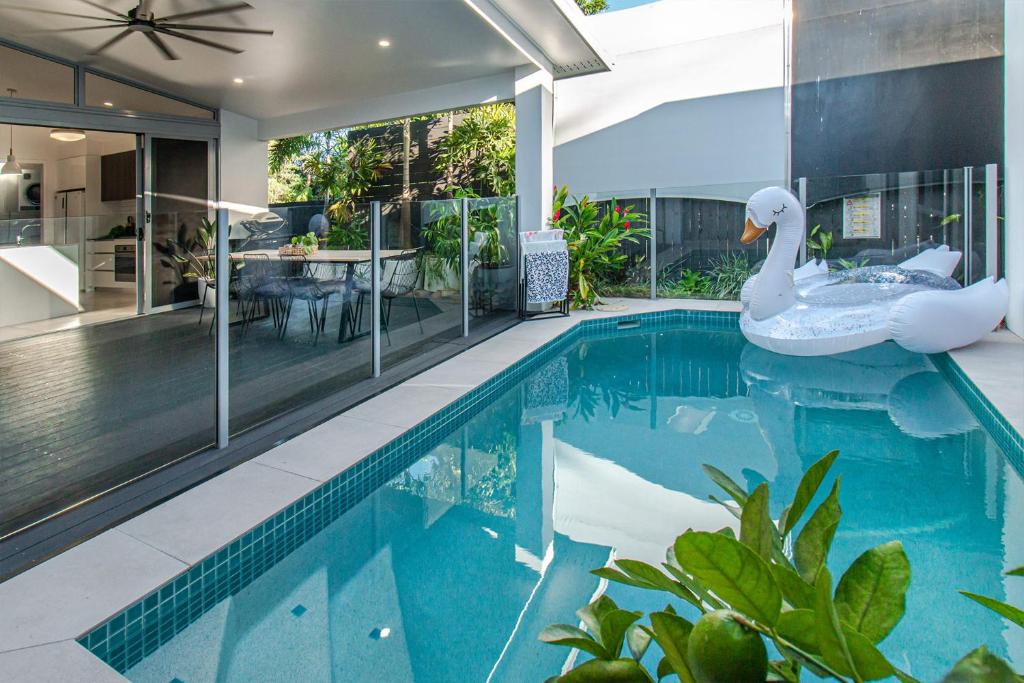 凯恩斯Pembroke House - Inner city luxury的一座房子里带天鹅的游泳池