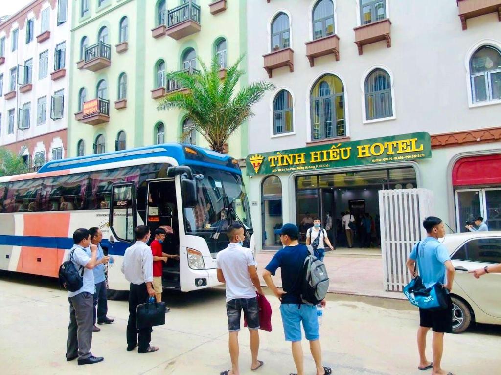 下龙湾Tình Hiếu Hotel的一群站在公共汽车外的人