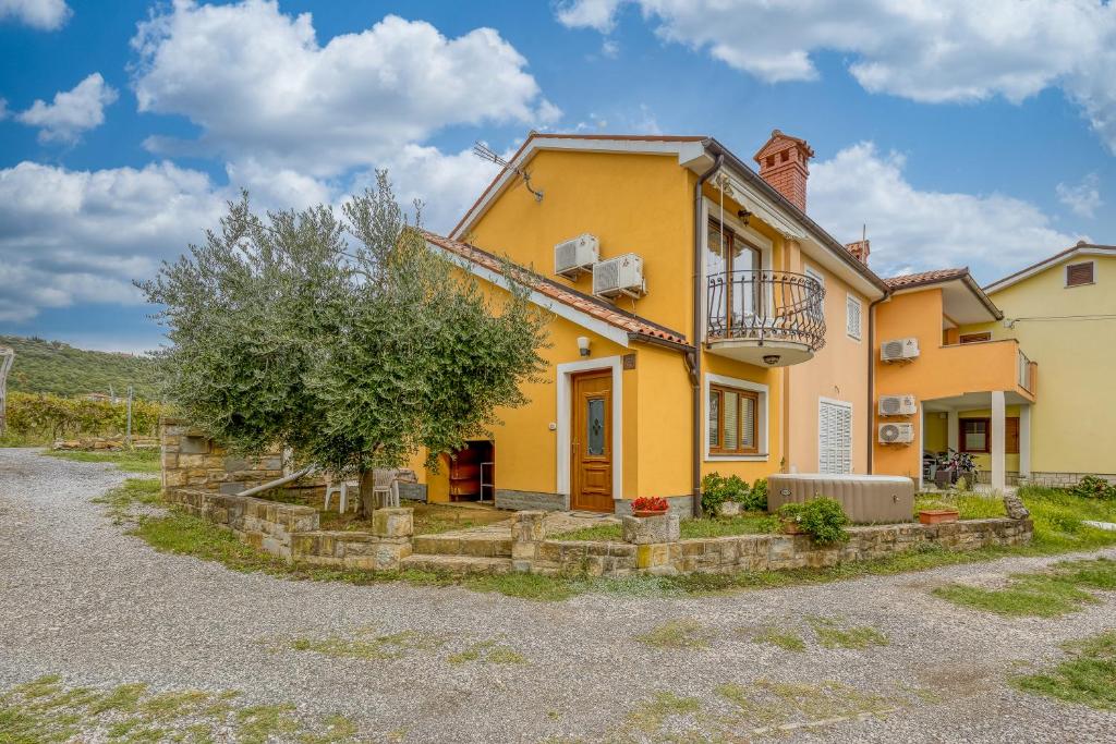 安卡兰House In The Vineyards - Happy Rentals的前面有一棵树的黄色房子