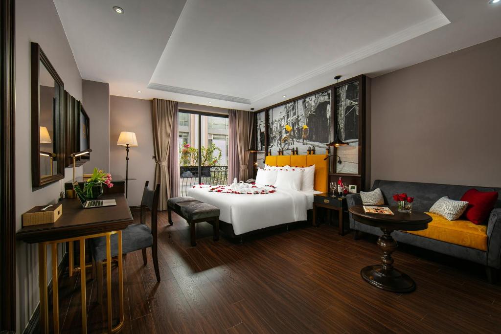 河内Hanoi Lion Boutique Hotel的酒店客房,配有床和沙发
