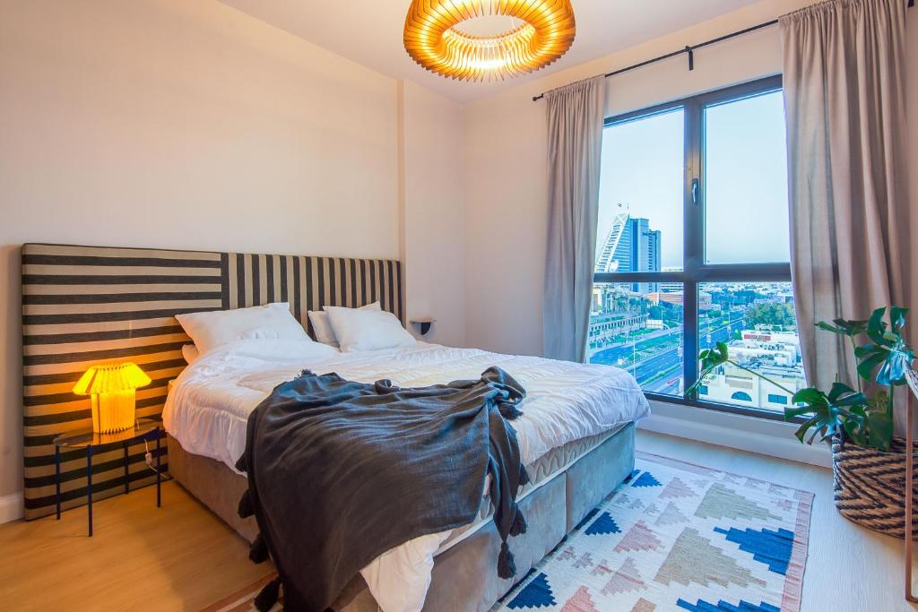 迪拜Burj Al Arab View - 1BR in MJL Lamtara 1- Sea View 703的一间卧室设有一张床和一个大窗户