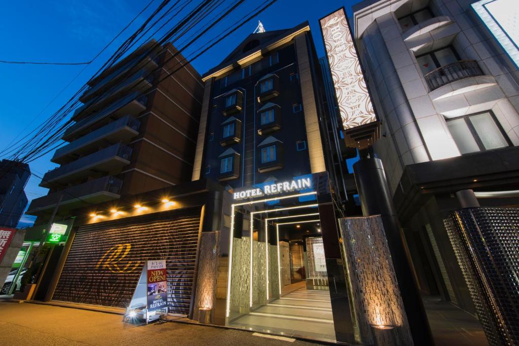 东京HOTEL REFRAIN的建筑前有标志的酒店外墙
