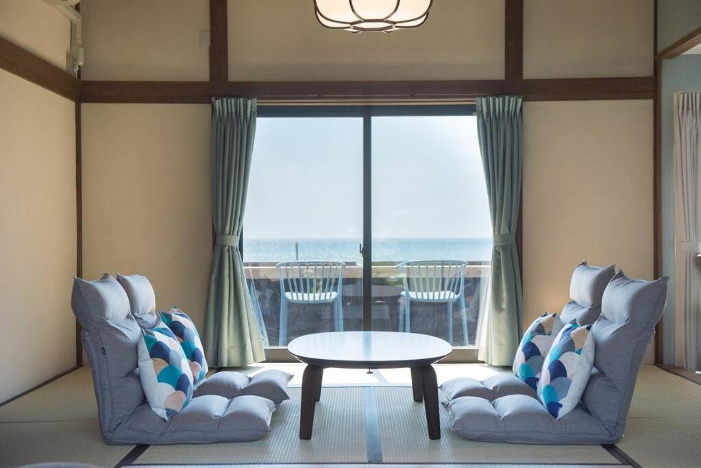 出云市Jikukan Mukae的客厅配有两把椅子、一张桌子和一扇窗户