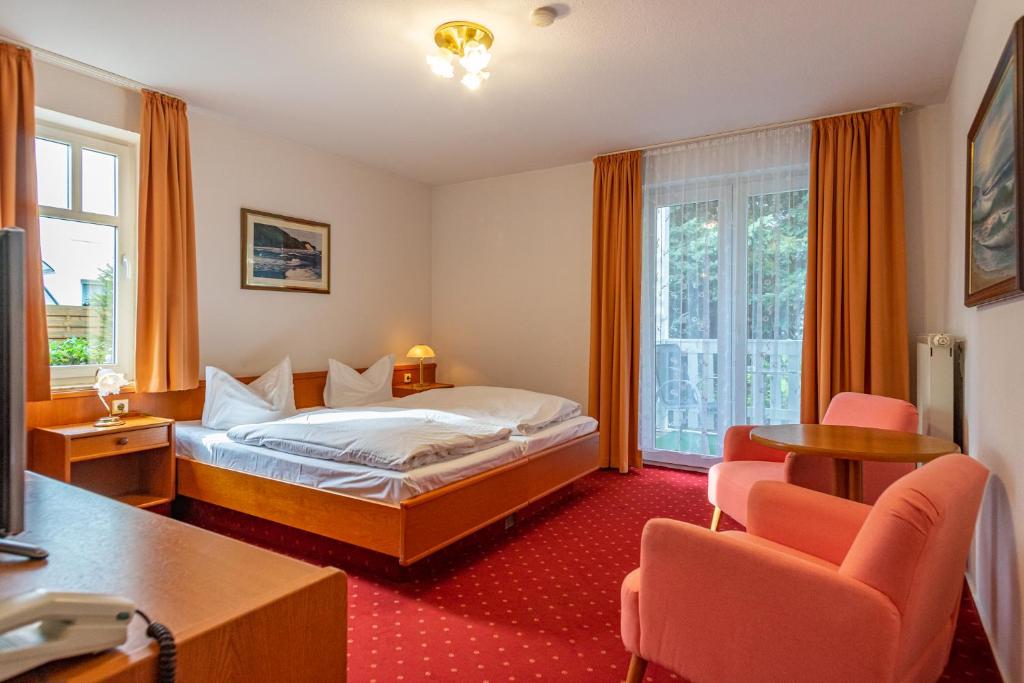 卑尔根Pension Bergen的酒店客房,配有一张床和两把椅子