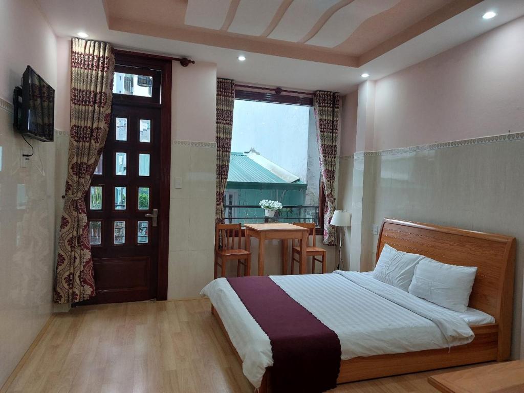 大叻New Sleep in Dalat Hostel的一间卧室设有床、窗户和门