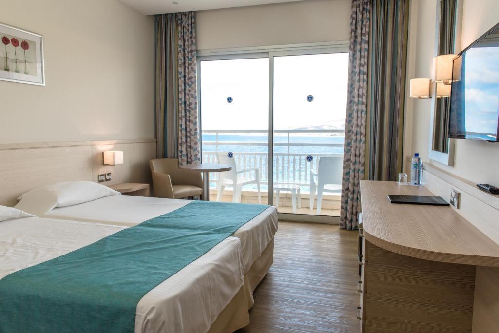 帕福斯辛西安纳海滩酒店的酒店客房设有一张床和一个大窗户