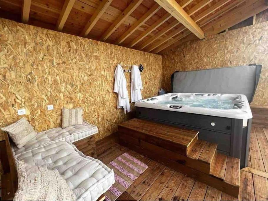 Saint-Félix-de-TournegatGite à la ferme avec jacuzzi et piscine chauffée的一间带浴缸的浴室,位于一间设有床铺的客房