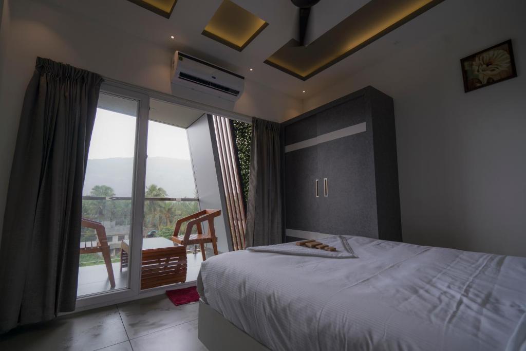PerintalmannaBBC Luxury Apartments的一间卧室设有一张床和一个享有美景的大窗户