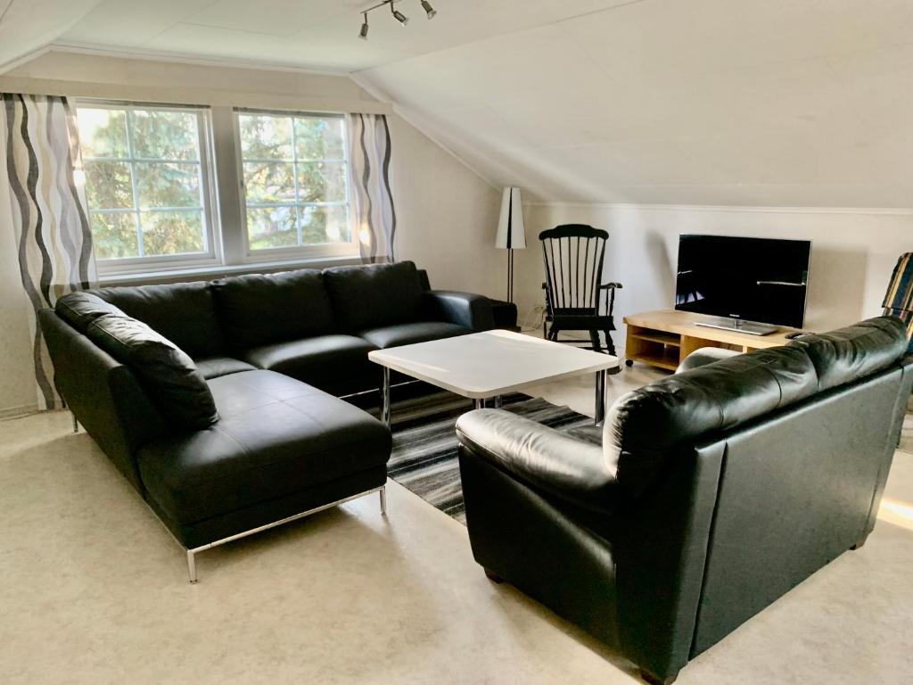 NärpiöCentral Apartment Närpes的客厅配有两张真皮沙发和一张桌子