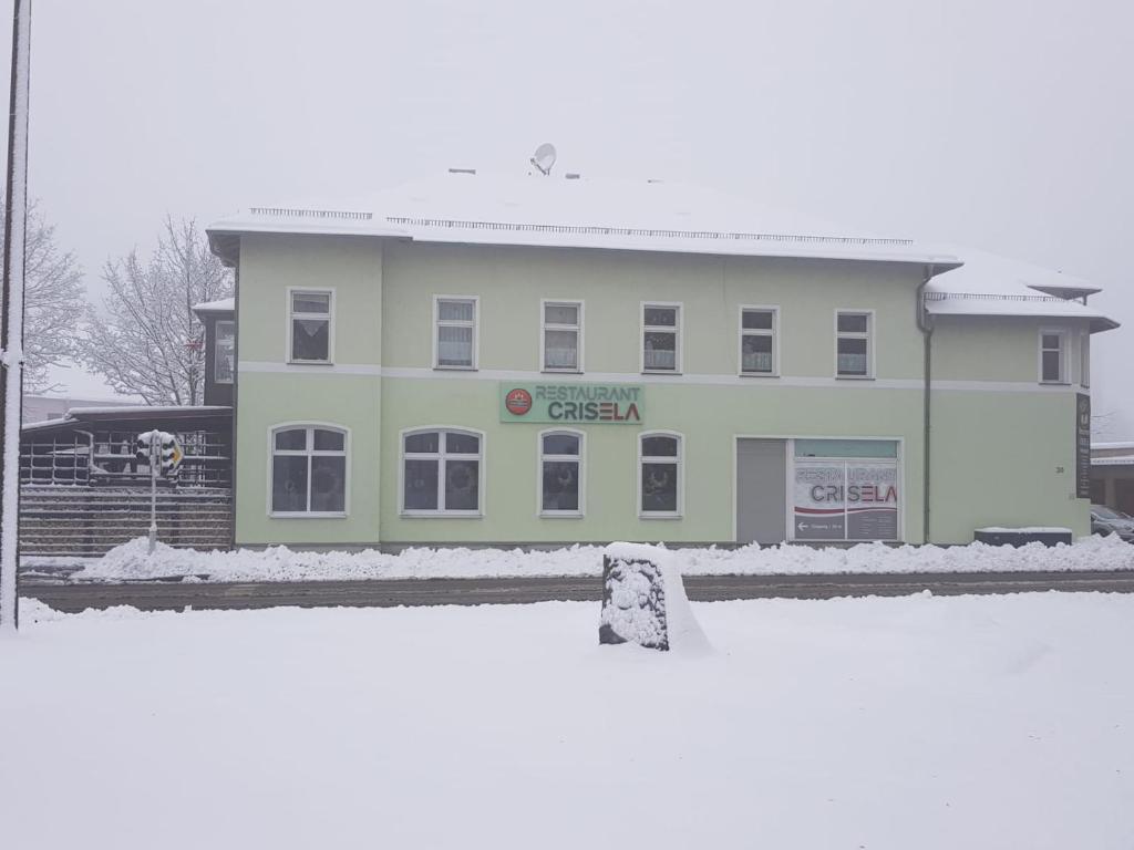Ebersbach SachsenFerienwohnung am Crisela的雪上有标志的白色建筑