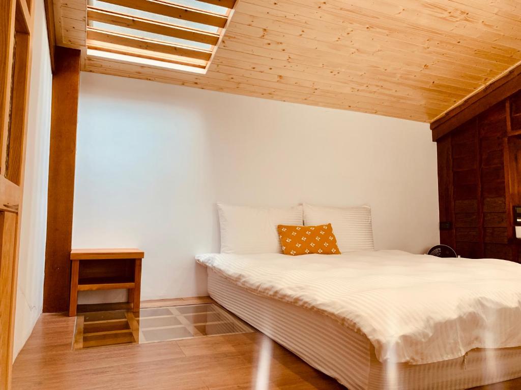 台南末廣通一館 日式包棟民宿 Suehirodori Japanese Entire Homes No1的卧室配有白色床和木制天花板
