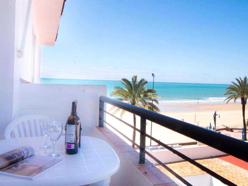 诺沃桑克蒂佩特里La Barrosa con vistas al mar的一张桌子上的一瓶葡萄酒,享有海滩美景