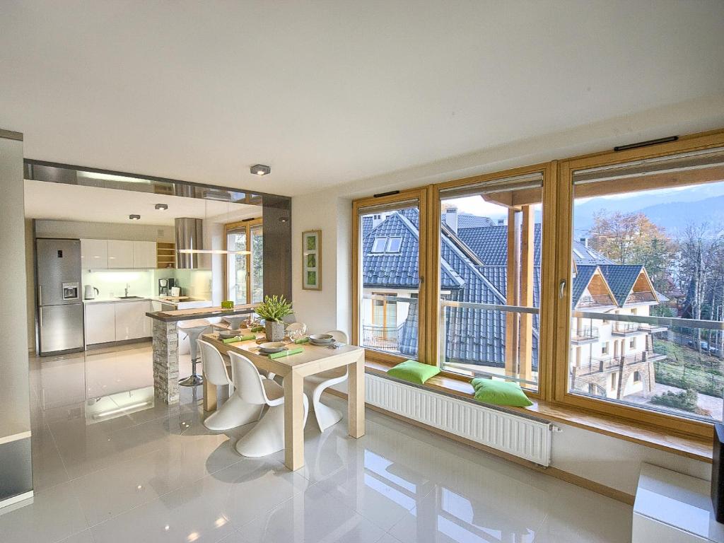 扎科帕内VisitZakopane - Aquapark Residence Lux Apartment的厨房以及带大窗户的用餐室。