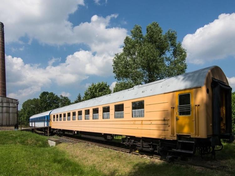 瓦恩斯多夫Vagónové ubytování Pivovar Kocour的一条黄色的火车正坐在轨道上