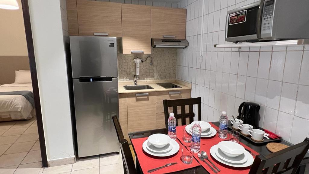 科威特科威特公寓的一个带红色桌布桌子的小厨房