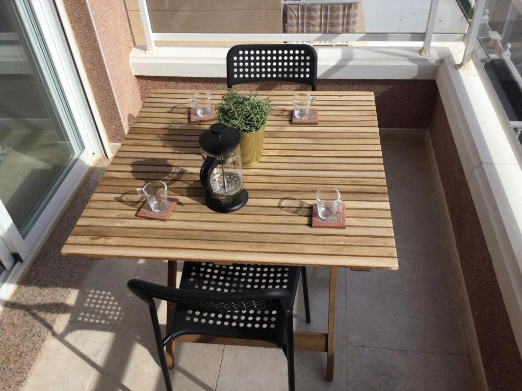 贝利雷瓜尔德Montgo 2 Bellreguard的阳台上的木桌,配有两把椅子和一张桌子