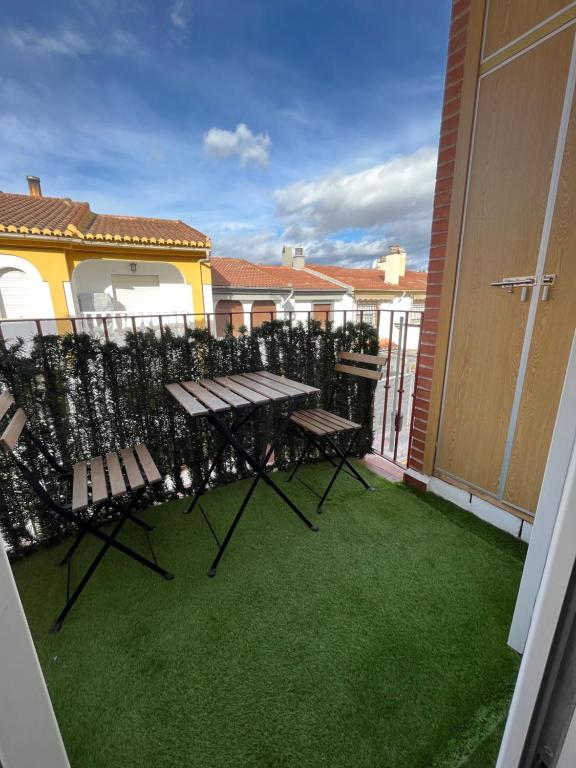 阿尔米利亚Apartamento y Parking的阳台配有两把椅子、桌子和草地