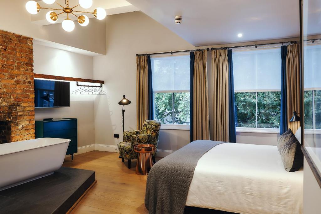 伦敦The Brownswood的卧室配有床、浴缸和窗户。