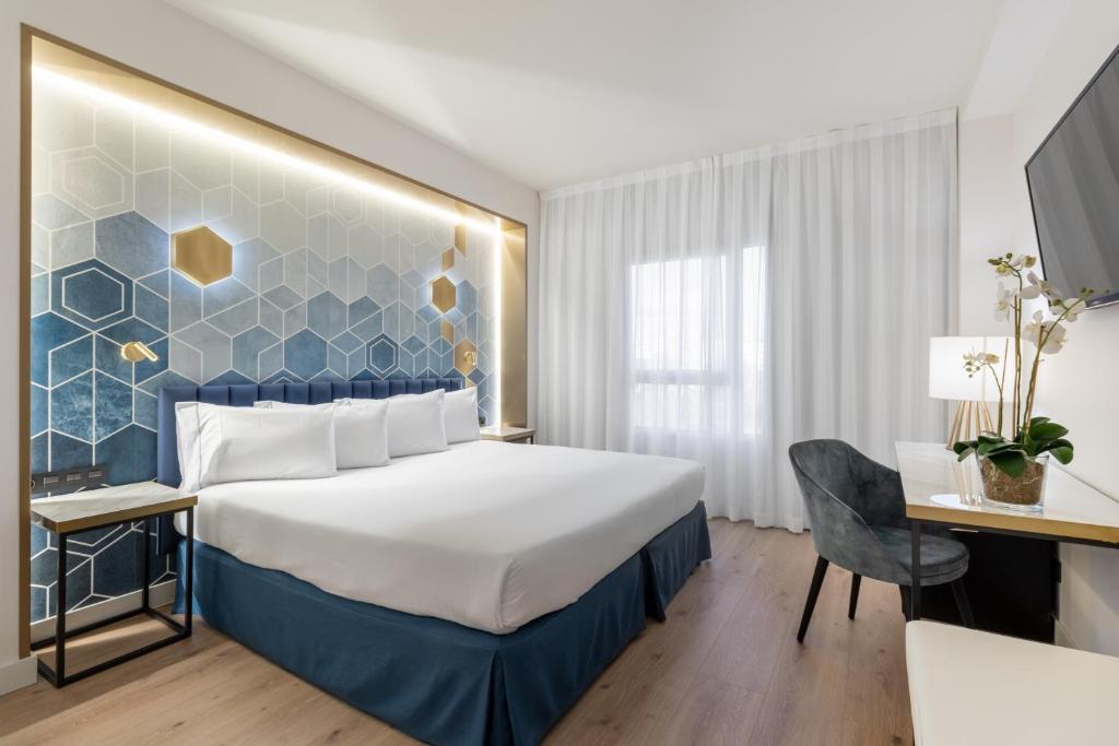 阿尔考本达斯欧洲之星格兰马德里酒店的配有一张床和一张书桌的酒店客房