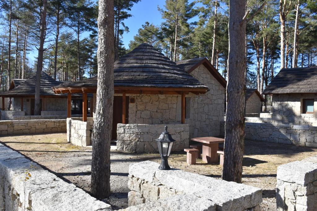 Alvão Village & Camping的石头建筑,带长凳和凉亭