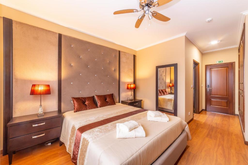 瓦戈斯Boa Vida Alojamentos的一间卧室配有一张大床和吊扇