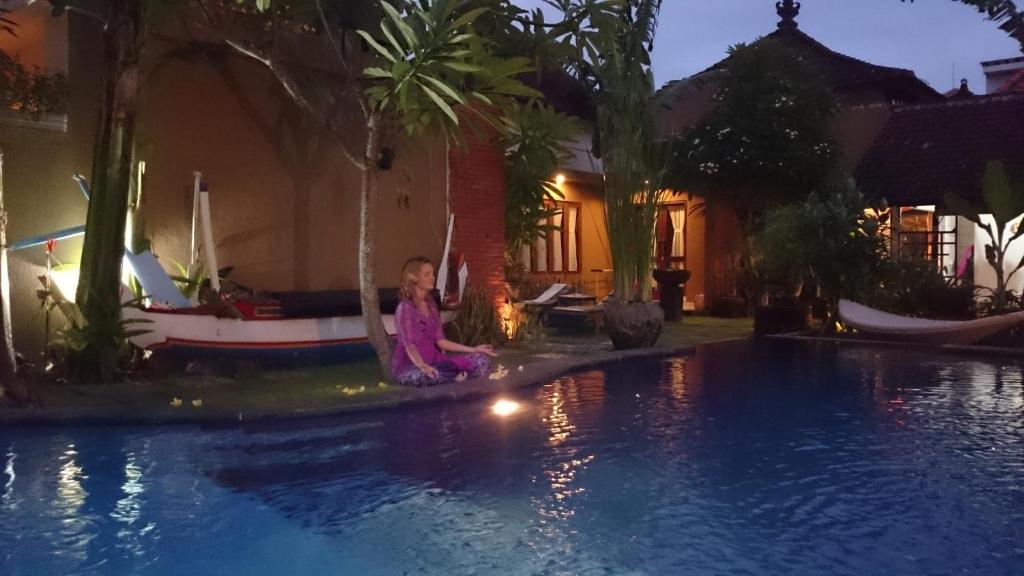 沙努尔巴厘巴厘岛普拉斯奇塔酒店的坐在游泳池旁的小女孩