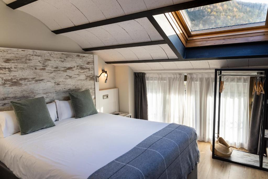坎普罗东Hotel Cims de Camprodon的一间卧室设有一张大床和一个窗户。