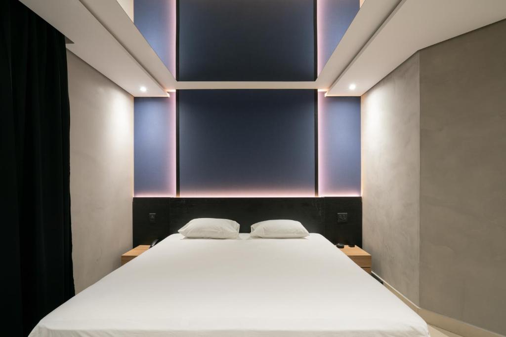 阿雷格里港Taikô Motel by Drops的一间卧室设有一张紫色墙壁的大床