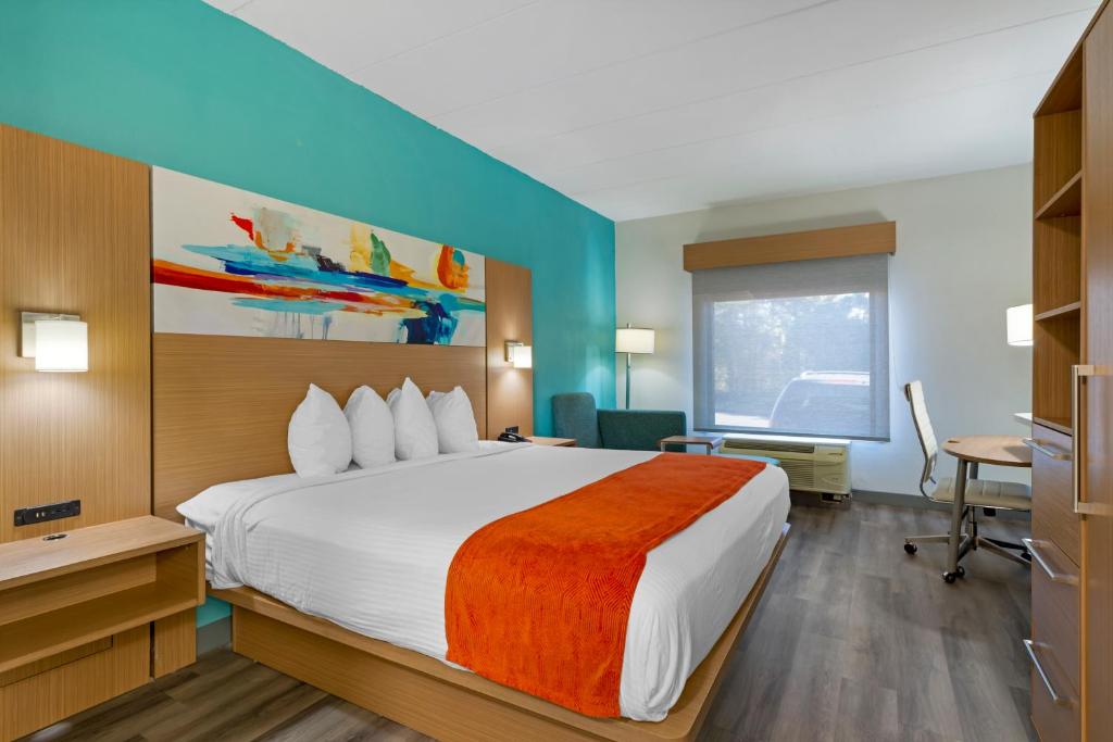 里士满Best Western PLUS Executive Hotel Richmond的酒店客房设有一张大床和一张书桌。